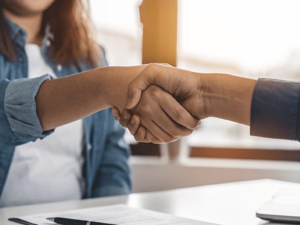 Homeowner and builder shaking hands over plans