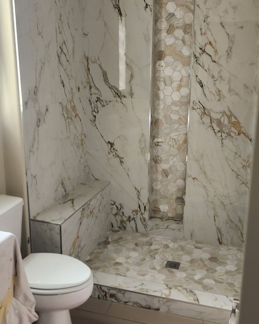 Marble shower with a tiled niche and bench